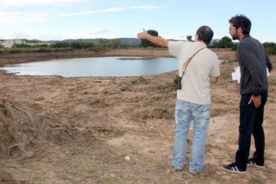 Ricardo Collado conversant amb un tècnic del Departament de Medi Ambient davant la llacuna permanent oberta a les Madrigueres. ACN