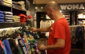 Un client comprova la roba en un comerç al juliol del 2015. ACN