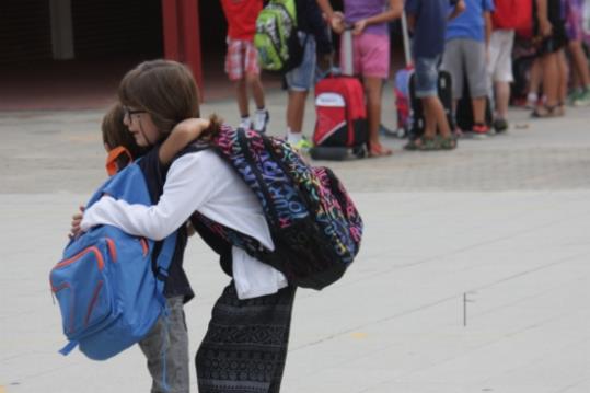 Dos companys s'abracen abans d'entrar a classe, a l'escola Duran i Bas de Barcelona, el primer dia d'escola, 14 de setembre de 2015. ACN