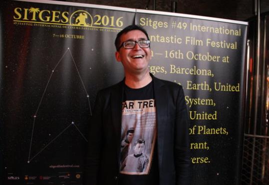 El director del Festival de Sitges, Ángel Sala, riu davant del cartell de la 49a edició del Festival (dedicat a l'univers 'Star Trek'), i llueix una s
