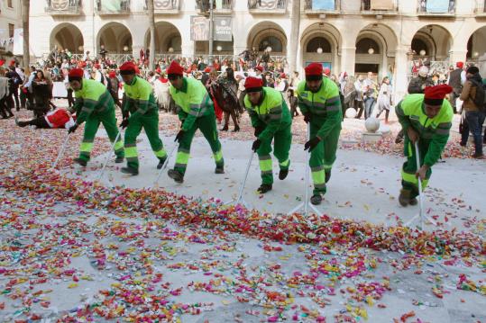 Pla general de mitja dotzena d'operaris de neteja de Vilanova i la Geltrú escombrant els quilos de caramels acumulats en la guerra de les Comparses. A