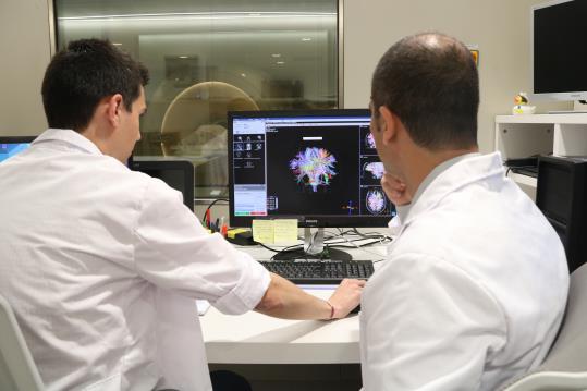 Pla mig de dos investigadors realitzant una ressonància magnètica a una voluntària de l'estudi Alfa. ACN