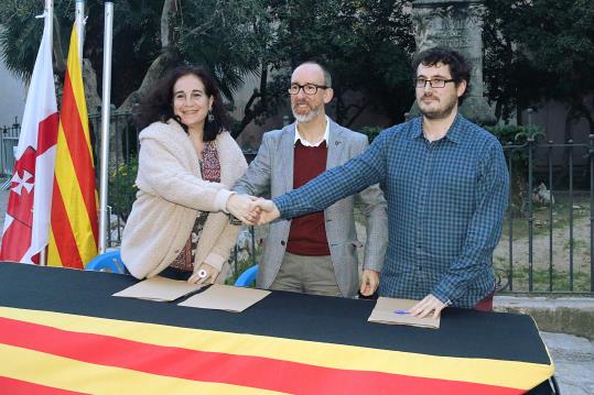 Pla obert d'Aurora Carbonell, Miquel Forns i Xavier Nin encaixant les mans, just després de signar l'acord d'estabilitat. ACN
