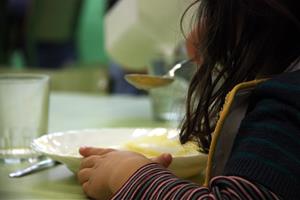 Imatge d'una nena d'esquena, menjant al menjador escolar. ACN