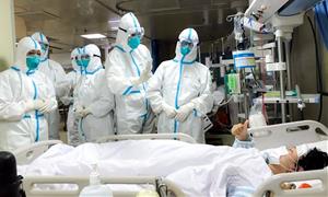 Pla general de sanitaris atenent un pacient a Shenzhen, a la Xina, amb els equips de protecció que es fan servir al país asiàtic, 31 de març de 2020. 