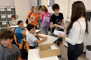 Una mestra de l'escola Gem de Mataró lliura els telèfons mòbils als alumnes de 1r d'ESO, un cop acabades les classes . ACN / Jordi Pujolar