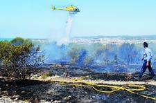 Un helicòpter llença aigua sobre la zona afectada pel foc, ahir al matí. FdG | C. Castro