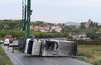 Una grua aixeca un camió de la Unitat de Serveis accidentat. FdG