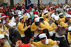 Un grup de comparsers llançant caramels a l'entrada de la plaça de la Vila ahir al matí.  fdg/c.castro