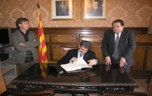 El conseller Joaquim Llena signa el llibre d'honor de l'Ajuntament.