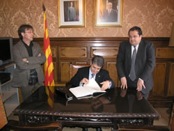 El conseller Joaquim Llena signa el llibre d'honor de l'Ajuntament.