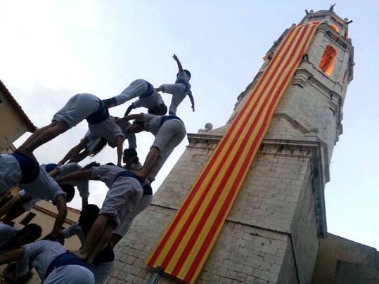 Imatge de l'hissada de la senyera al campanar de Sant Antoni, inici de la festa major d'enguany