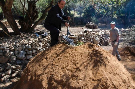 Ajuntament de Calafell. Un centenar de persones assisteixen a la construcció duna carbonera a la Ciutadella Ibèrica