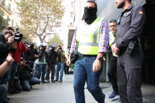 Agents de la Guàrdia Civil sortint de la seu de CDC on estan escorcollant. ACN