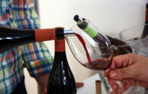 Detall d'un visitant omplint la seva copa amb vi negre a la 27a edició de la Festa del Vi de Gandesa. ACN