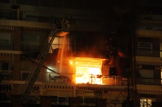 Els bombers treballen en l'extinció d'un incendi en un habitatge al carrer Mejía Lequerica de les Corts. ACN