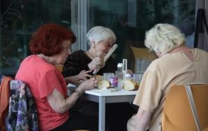 Gent gran asseguda en una taula del servei 'Àpats en companyia'. ACN