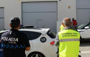 Imatge d'un agent de la Policia Local de Calafell i d'un guia de la unitat canina de la Guàrdia Civil, durant el registre a un club cannàbic. Guàrdia 