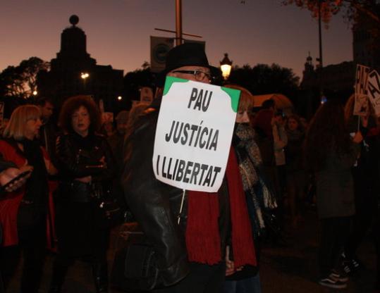 Un dels participants de la manifestació per la Pau, al carrer Fontanella i ocult darrere un cartell en què es llegeix 