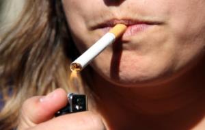 Una fumadora encenent un cigarret amb un encenedor. ACN