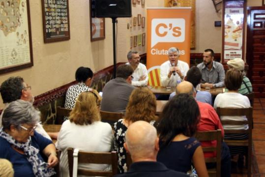 Uns veïns en un bar de Cunit escoltant al candidat de C's per Tarragona, Matías Alonso . ACN