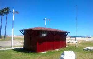 Antiga caseta de la Creu Roja avui tancada i barrada i amb el màstil sense bandera indicativa de l'estat de la mar. Eix