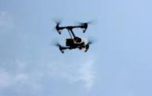 Detall d'un dron enlairat, enmig del cel