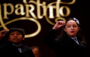 Dos nens de San Ildefonso cantant un dels dos quarts premis de la Rifa de Nadal, el 59444. ACN