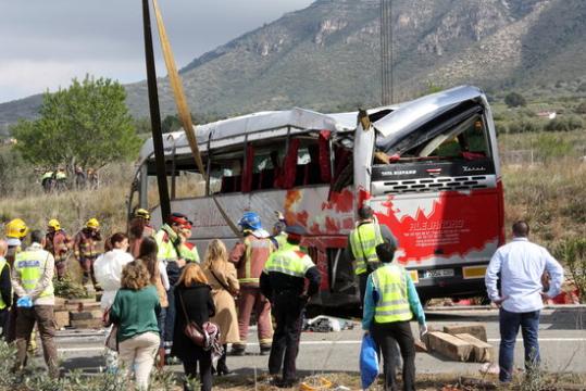 Efectius dels Bombers i Mossos observant l'autobús accidentat un cop la grua l'ha aixecat. ACN