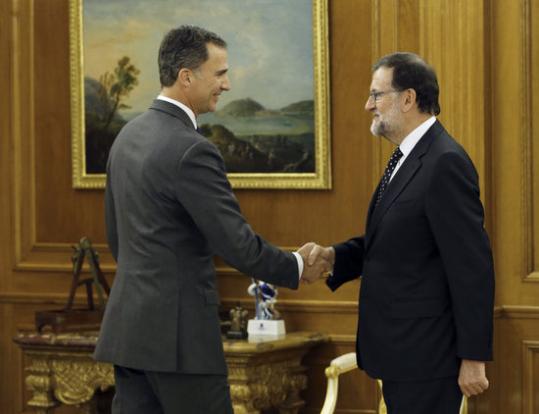 El candidat del PP a la presidència del govern espanyol, Mariano Rajoy, i el rei Felip VI, encaixant mans a La Zarzuela. Pool