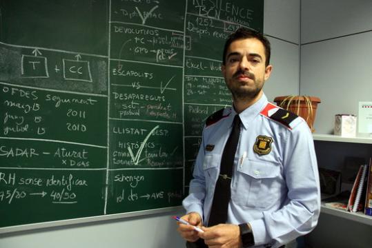 El caporal dels Mossos Daniel Cejas al costat de la pissarra on escriuen els objectius de l'Oficina d'Atenció a les Famílies de Persones Desaparegudes