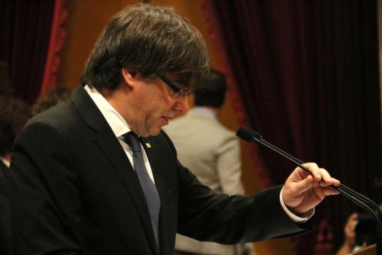 El president de la Generalitat, Carles Puigdemont, agafa un dels micròfons del faristol del Parlament. ACN