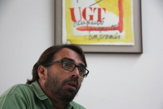 El secretari general d'UGT, Camil Ros, sota un cartell del sindicat. ACN