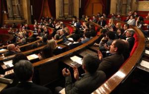 Els diputats del Parlament aplaudeixen a l'hemicicle després de l'aprovació unànime de la proposta de resolució sobre la recuperació de la paga extra.