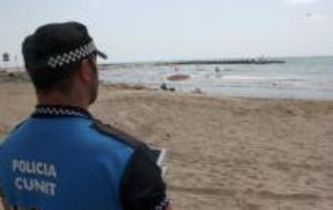 En primer pla, un agent de la Policia Local de Cunit pilotant el dron a les platges, amb l'aparell a la llunyania, sobre el mar