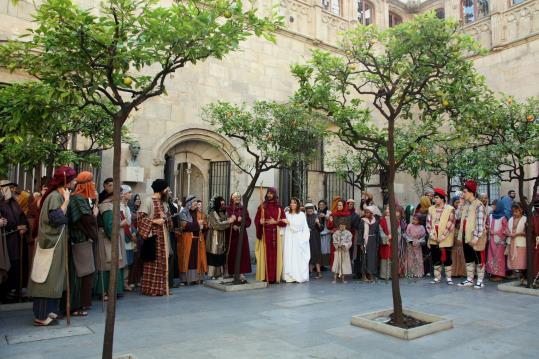 Habitants de Betlem amb branques de palma donen l'enhorabona a Josep i Maria en el seu casori, escena dels Pastorets al Pati dels Tarongers. ACN