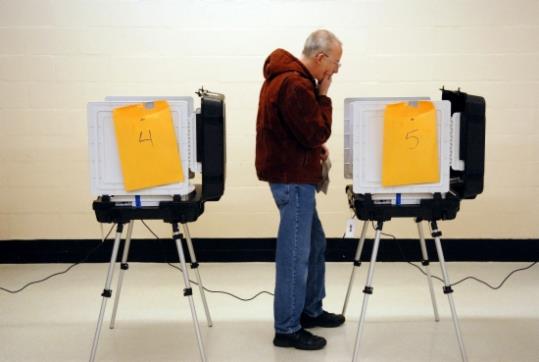 Imatge d'arxiu d'un home llegint la pantalla de la màquina electrònica de votació. ACN