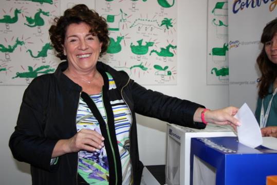 Imatge de Sílvia Requena, somrient mirant a càmera, en el moment que introdueix la papereta dins una de les urnes del 'súperdissabte' de CDC. ACN