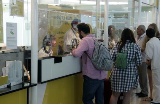 Imatge d'un passatger als taulells d'atenció al cient de Vueling a l'aeroport del Prat. ACN