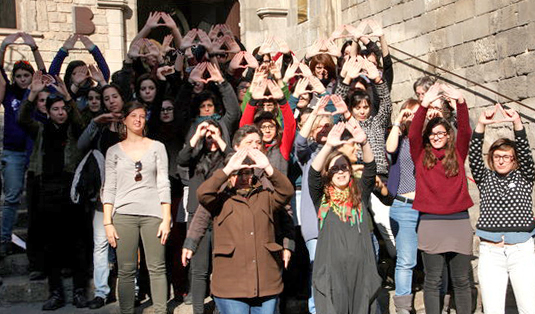 Les dones de la CUP fent el símbol feminista amb les mans, a l'acte contra el masclisme. ACN / Rafa Garrido