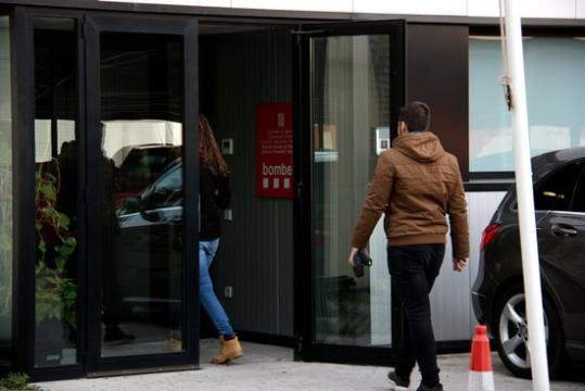 Membres de la UDEF vestits de paisà entrant d'esquena a la porta principal l'edifici d'oficines del Parc de Bombers de Sant Boi de Llobregat. ACN