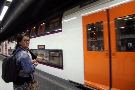 Pla general de dos usuàries i el tren de fons. Renfe. Rodalies. ACN