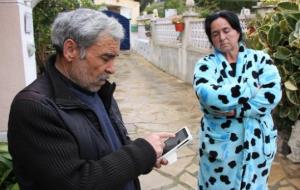 Pla mig dels pares de l'home mort a Cunit durant una reducció policial. El pare sosté el telèfon mòbil on té fotografies dels fets. ACN