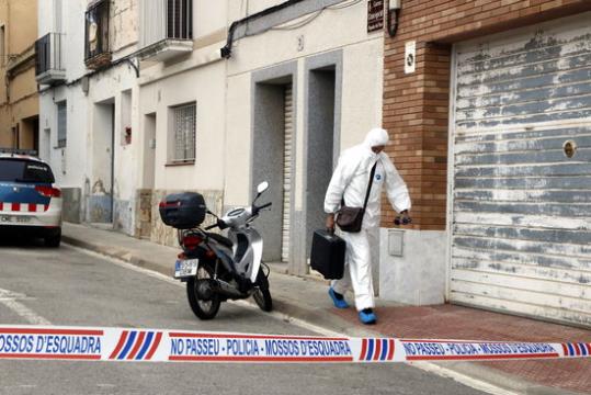 Un agent de la policia científica surt del domicili -número 3- de Masquefa on s'ha localitzat una dona morta amb signes de violència. ACN