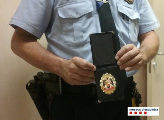 Un agent mostra la credencial falsa utilitzada per cometre furts fent-se passar com a policia. Mossos d'Esquadra