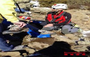 Un bomber de l'equip de rescat parlant amb l'excursionista accidentat al Montseny