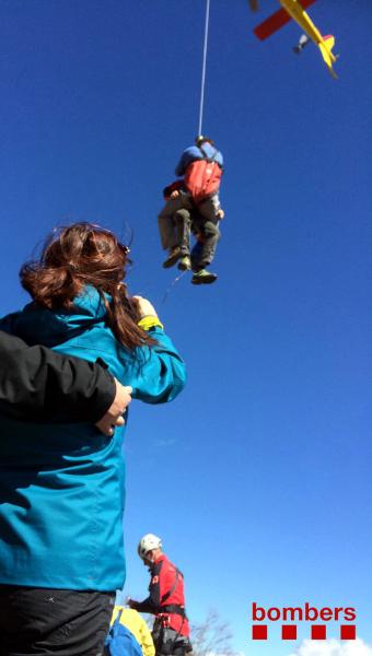 Un bomber de l'equip de rescat parlant amb l'excursionista accidentat al Montseny. Bombers