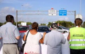 Un grup de manifestants d'esquena tallen la C-31 a Cubelles a la rotonda d'accés a l'autopista C-32. ACN