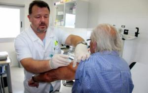 Un infermer posant la vacuna de la grip a un pacient al consultori mèdic d'Alpicat. ACN