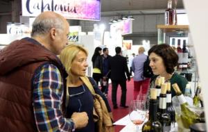 Una representant d'un celler exposat a Alimentària conversa amb dos visitants de la fira